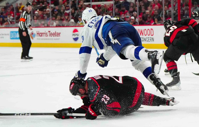 Nov 24, 2023; Raleigh, North Carolina, USA; Tampa Bay Lightning center Michael Eyssimont (23) checks Carolina Hurricanes right wing Stefan Noesen (23) during the third period at PNC Arena. Mandatory Credit: James Guillory-USA TODAY Sports