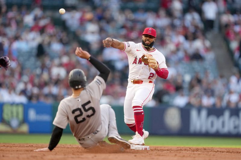 May 28, 2025; Anaheim, California, USA; Los Angeles Angels second baseman Luis Rengifo (2) forces out New York Yankees catcher J.C. Escarra (25) out at second base in the second inning at Angel Stadium. Mandatory Credit: Kirby Lee-Imagn Images