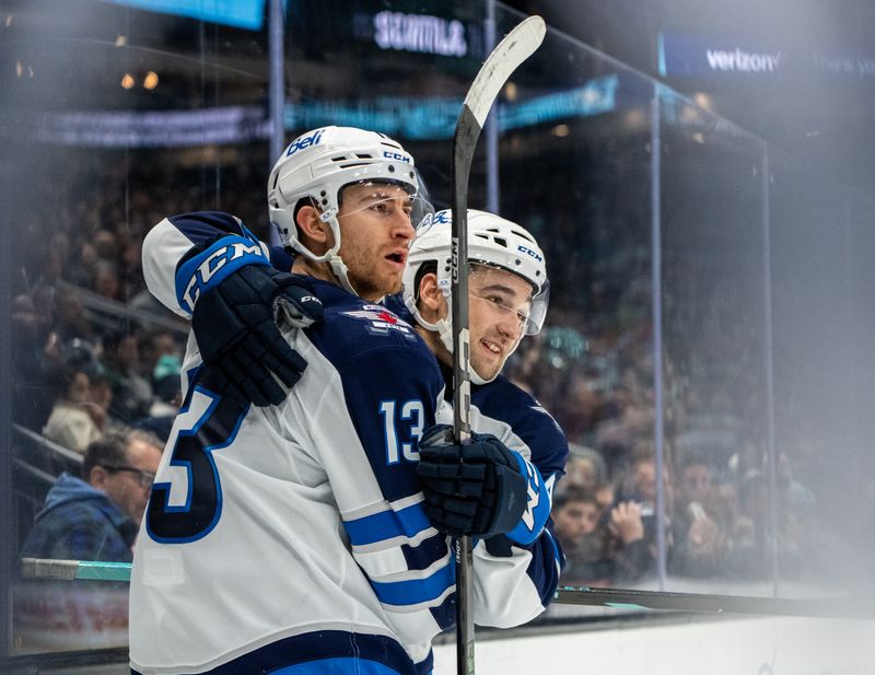 Oct 24, 2024; Seattle, Washington, USA;  Winnipeg Jets forward Gabriel Vilardi (13) celebrates with defenseman Neal Pionk (4) after scoring a goal during the second period against the Seattle Kraken at Climate Pledge Arena. Mandatory Credit: Stephen Brashear-Imagn Images