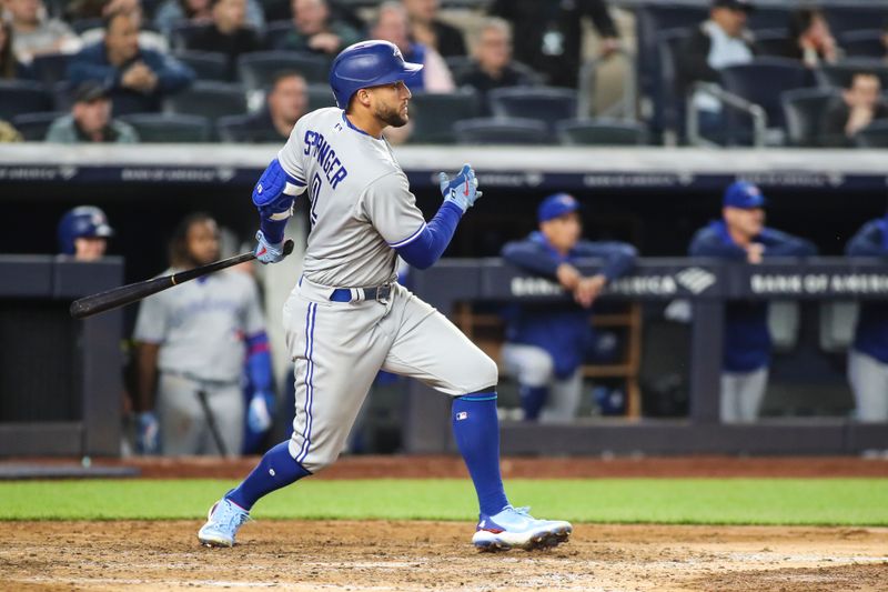 Apr 13, 2022; Bronx, New York, USA;  Toronto Blue Jays center fielder George Springer (4) hits an RBI single in the seventh inning against the New York Yankees at Yankee Stadium. Mandatory Credit: Wendell Cruz-USA TODAY Sports