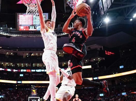 TORONTO, ON - DECEMBER 23: Scottie Barnes #4 of the Toronto Raptors goes to the basket against Walker Kessler #24 of the Utah Jazz during the second half of their basketball game at the Scotiabank Arena on December 23, 2023 in Toronto, Ontario, Canada. NOTE TO USER: User expressly acknowledges and agrees that, by downloading and/or using this Photograph, user is consenting to the terms and conditions of the Getty Images License Agreement. (Photo by Mark Blinch/Getty Images)