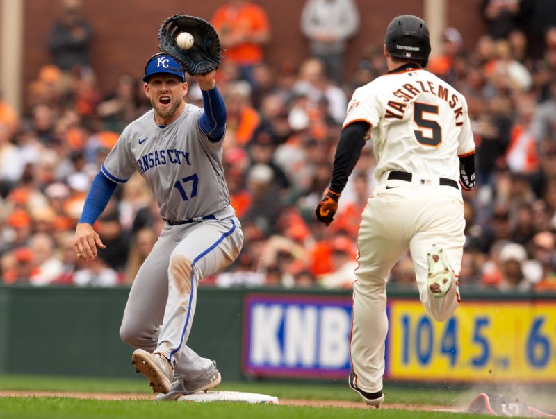 Apr 7, 2023; San Francisco, California, USA; Kansas City Royals first baseman Hunter Dozier (17) takes the relay in time to retire San Francisco Giants center fielder Mike Yastrzemski (5) on a bunt attempt during the sixth inning at Oracle Park. Mandatory Credit: D. Ross Cameron-USA TODAY Sports