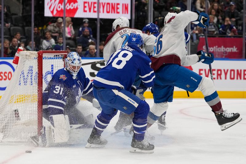 Jan 13, 2024; Toronto, Ontario, CAN; Toronto Maple Leafs goaltender Martin Jones (31) makes a save as Colorado Avalanche defenseman Kurtis MacDermid (56) and forward Fredrik Olofsson (22) crash the net during the second period at Scotiabank Arena. Mandatory Credit: John E. Sokolowski-USA TODAY Sports