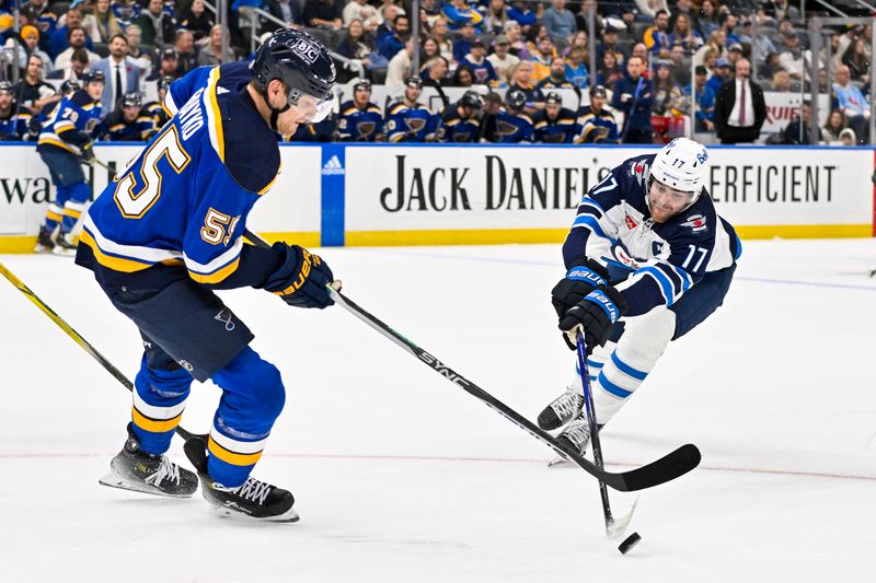 Nov 7, 2023; St. Louis, Missouri, USA;  Winnipeg Jets center Adam Lowry (17) and St. Louis Blues defenseman Colton Parayko (55) battle for the puck during the first period at Enterprise Center. Mandatory Credit: Jeff Curry-USA TODAY Sports