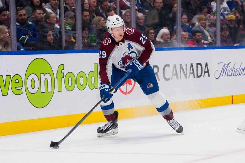 Mar 13, 2024; Vancouver, British Columbia, CAN; Colorado Avalanche forward Nathan MacKinnon (29) handles the puck against the Vancouver Canucks in the second period at Rogers Arena. Mandatory Credit: Bob Frid-USA TODAY Sports