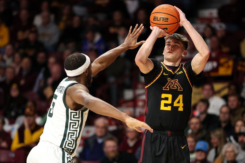 Dec 4, 2024; Minneapolis, Minnesota, USA; Minnesota Golden Gophers guard Brennan Rigsby (24) shoots as Michigan State Spartans guard Tre Holloman (5) defends during the first half at Williams Arena. Mandatory Credit: Matt Krohn-Imagn Images