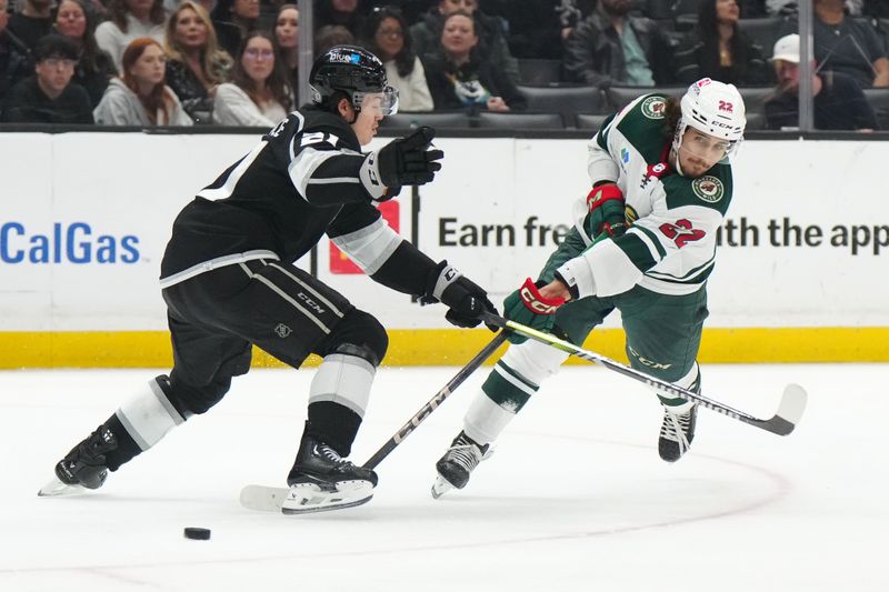 Apr 15, 2024; Los Angeles, California, USA; Minnesota Wild center Marat Khusnutdinov (22) shoots the puck against LA Kings defenseman Jordan Spence (21) in the third period at Crypto.com Arena. Mandatory Credit: Kirby Lee-USA TODAY Sports