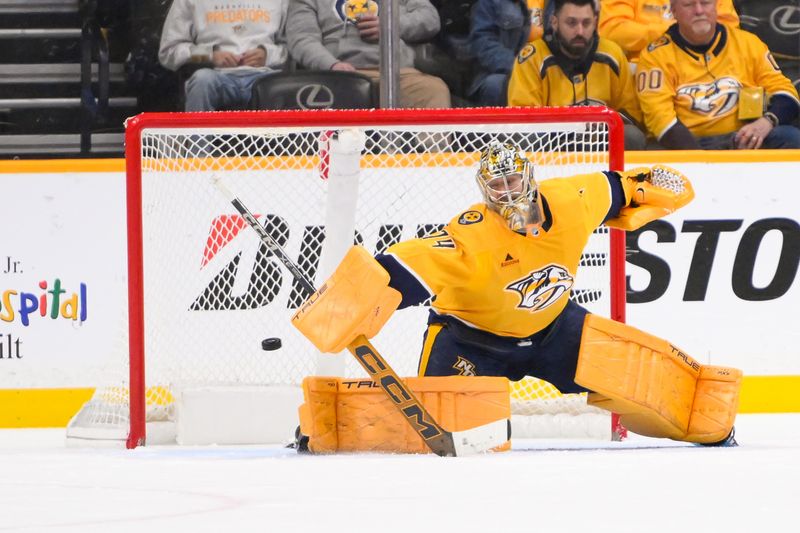 Jan 18, 2025; Nashville, Tennessee, USA;  Nashville Predators goaltender Juuse Saros (74) blocks the puck against the Minnesota Wild during the third period at Bridgestone Arena. Mandatory Credit: Steve Roberts-Imagn Images