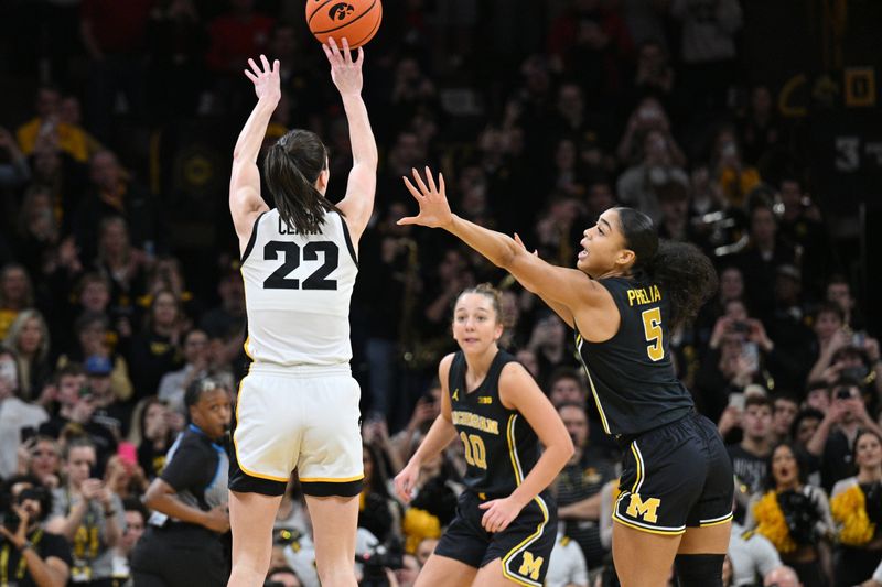 Feb 15, 2024; Iowa City, Iowa, USA; Iowa Hawkeyes guard Caitlin Clark (22) hits a three point basket to break the NCAA women's all-time scoring record as Michigan Wolverines guard Laila Phelia (5) defends at Carver-Hawkeye Arena. Mandatory Credit: Jeffrey Becker-USA TODAY Sports