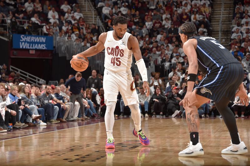 CLEVELAND, OH - APRIL 22: Donovan Mitchell #45 of the Cleveland Cavaliers handles the ball against Paolo Banchero #5 of the Orlando Magic during the game during Round 1 Game 2 of the 2024 NBA Playoffs on April 22, 2024 at Rocket Mortgage FieldHouse in Cleveland, Ohio. NOTE TO USER: User expressly acknowledges and agrees that, by downloading and/or using this Photograph, user is consenting to the terms and conditions of the Getty Images License Agreement. Mandatory Copyright Notice: Copyright 2024 NBAE (Photo by David Liam Kyle/NBAE via Getty Images)