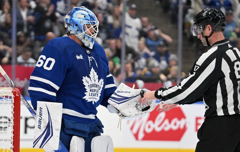 May 2, 2024; Toronto, Ontario, CAN; Toronto Maple Leafs goalie Joseph Woll (60) hands the puck to linesman Devin Berg (87) after making a save against the Boston Bruins in the second period in game six of the first round of the 2024 Stanley Cup Playoffs at Scotiabank Arena. Mandatory Credit: Dan Hamilton-USA TODAY Sports