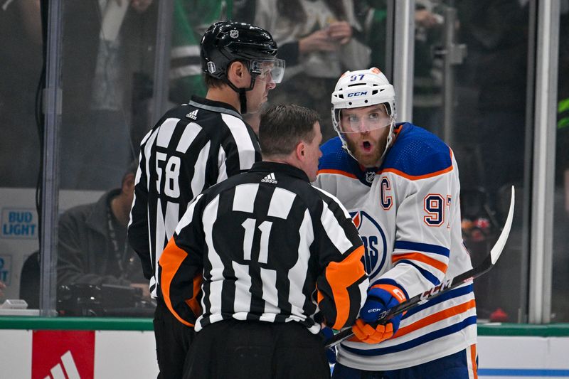 May 23, 2024; Dallas, Texas, USA; Edmonton Oilers center Connor McDavid (97) argues with referee Kelly Sutherland (11) after McDavid is called for a four minute high sticking penalty against the Dallas Stars during the overtime period in game one of the Western Conference Final of the 2024 Stanley Cup Playoffs at American Airlines Center. Mandatory Credit: Jerome Miron-USA TODAY Sports