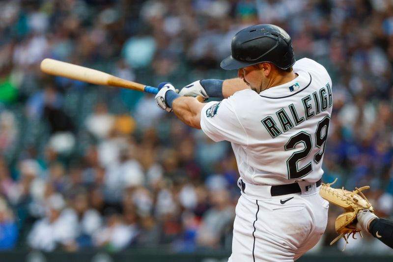 Jun 13, 2023; Seattle, Washington, USA; Seattle Mariners catcher Cal Raleigh (29) hits a three-run home run against the Miami Marlins during the second inning at T-Mobile Park. Mandatory Credit: Joe Nicholson-USA TODAY Sports