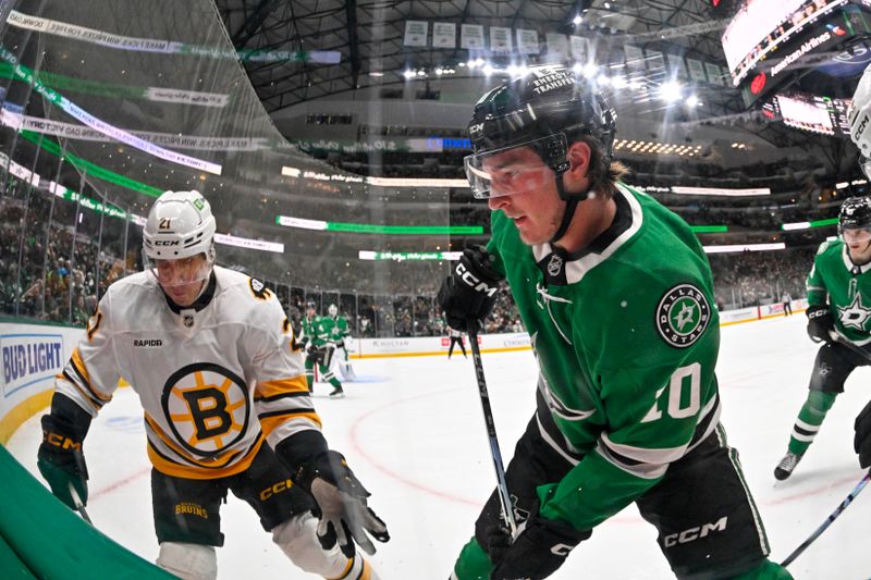 Jan 20, 2026; Dallas, Texas, USA;  Boston Bruins center Alex Steeves (21) and Dallas Stars center Oskar Back (10) battle for control of the puck during the third period at the American Airlines Center. Mandatory Credit: Jerome Miron-Imagn Images