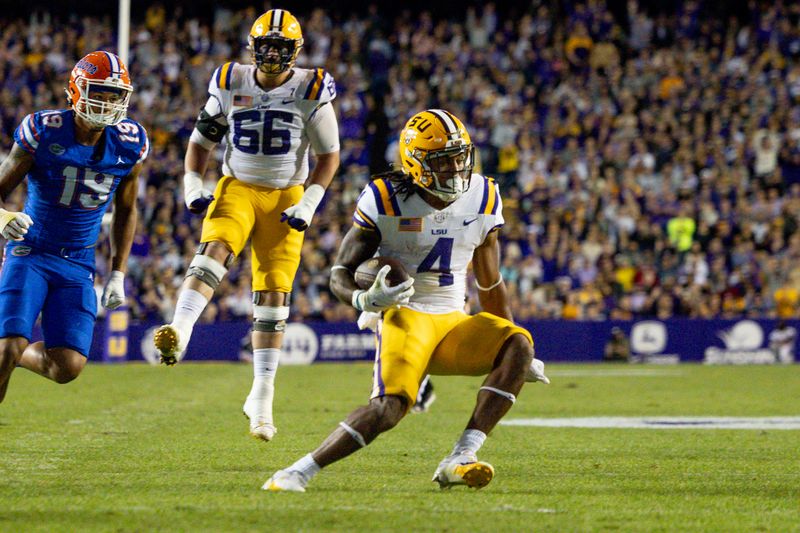 Nov 11, 2023; Baton Rouge, Louisiana, USA;  LSU Tigers running back John Emery Jr. (4) rushes against Florida Gators defensive end T.J. Searcy (19) during the first half at Tiger Stadium. Mandatory Credit: Stephen Lew-USA TODAY Sports