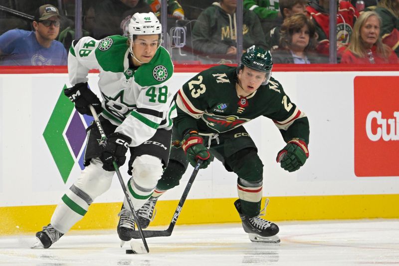 Sep 29, 2024; Saint Paul, Minnesota, USA;  Dallas Stars forward Chase Wheatcroft (48) protects the puck from Minnesota Wild forward Marco Rossi (23) during the second period at Xcel Energy Center. Mandatory Credit: Nick Wosika-Imagn Images