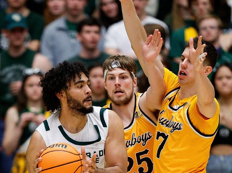 Feb 15, 2025; Fort Collins, Colorado, USA; Colorado State Rams forward Rashaan Mbemba (21) controls the ball under pressure from Wyoming Cowboys forward Touko Tainamo (25) and forward Matija Belic (7) in the first half at Moby Arena. Mandatory Credit: Isaiah J. Downing-Imagn Images