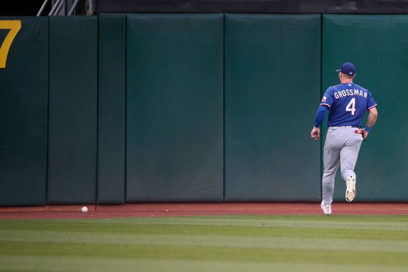 Aug 7, 2023; Oakland, California, USA; Texas Rangers outfielder Robbie Grossman (4) chases the ball after misjudging a fly ball against the Oakland Athletics during the third inning at Oakland-Alameda County Coliseum. Mandatory Credit: Robert Edwards-USA TODAY Sports