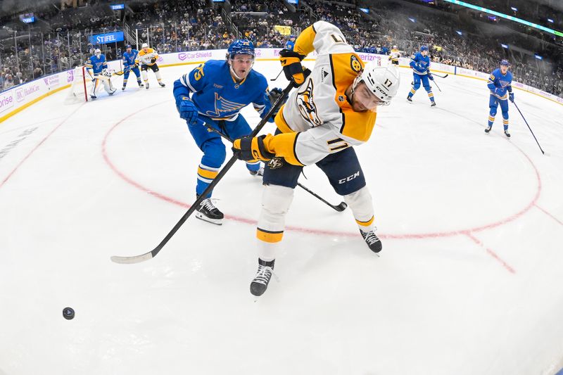 Dec 15, 2025; St. Louis, Missouri, USA; Nashville Predators center Tyson Jost (17) passes the puck as St. Louis Blues defenseman Tyler Tucker (75) defends during the third period at Enterprise Center. Mandatory Credit: Jeff Curry-Imagn Images