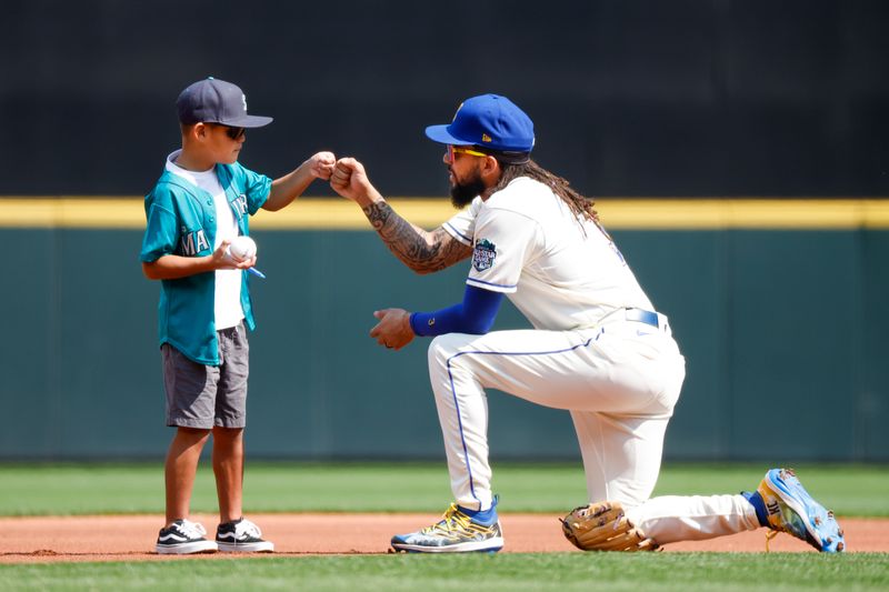 Aug 27, 2023; Seattle, Washington, USA; Seattle Mariners shortstop J.P. Crawford (3) bumps fists with a young fan after signing an autograph before a game against the Kansas City Royals at T-Mobile Park. Mandatory Credit: Joe Nicholson-USA TODAY Sports