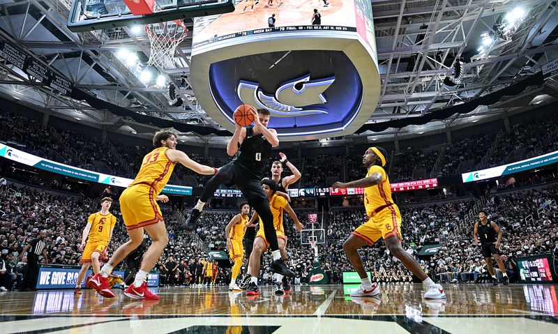 Jan 5, 2026; East Lansing, Michigan, USA;  Ringed by Southern California Trojans defenders, Michigan State Spartans forward Jaxon Kohler (0) comes down with an offensive rebound during the second half at Jack Breslin Student Events Center. Mandatory Credit: Dale Young-Imagn Images