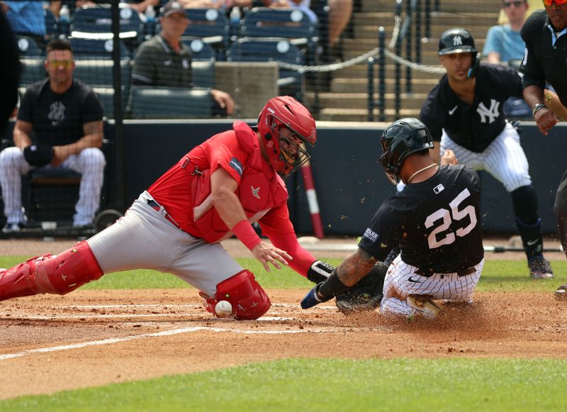 Mar 13, 2024; Tampa, Florida, USA; New York Yankees second baseman Gleyber Torres (25) slides safe into home plate as Boston Red Sox catcher Reese McGuire (3) attempts to tag him out during the first inning at George M. Steinbrenner Field. Mandatory Credit: Kim Klement Neitzel-USA TODAY Sports