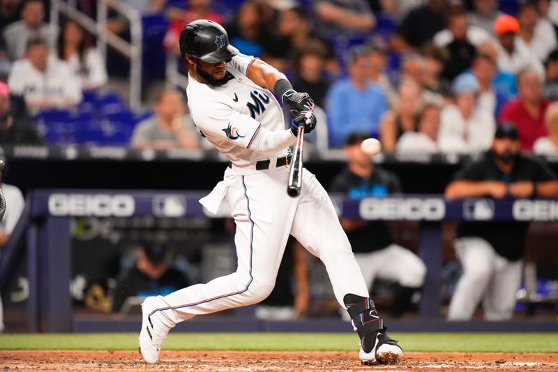 Jun 20, 2023; Miami, Florida, USA; Miami Marlins left fielder Bryan De La Cruz (14) hits a single against the Toronto Blue Jays during the seventh inning at loanDepot Park. Mandatory Credit: Rich Storry-USA TODAY Sports