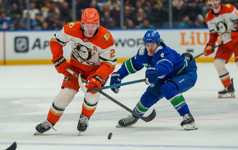 Jan 29, 2026; Vancouver, British Columbia, CAN;  Anaheim Ducks Defenseman Jackson LaCombe (2) chases the puck with Vancouver Canucks left wing Conor Garland (8) in the second period at Rogers Arena. Mandatory Credit: Christopher Morris-Imagn Images