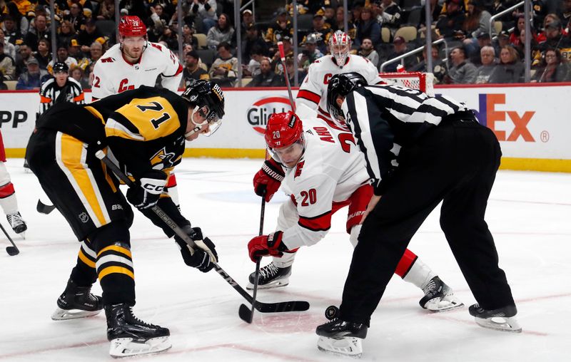 Mar 26, 2024; Pittsburgh, Pennsylvania, USA; Pittsburgh Penguins center Evgeni Malkin (71) and Carolina Hurricanes center Sebastian Aho (20) take a first period face-off at PPG Paints Arena. Mandatory Credit: Charles LeClaire-USA TODAY Sports