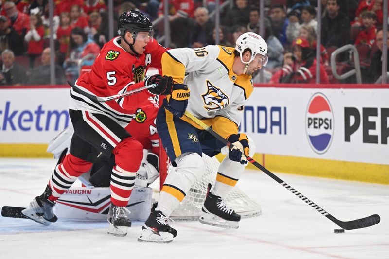 Apr 12, 2024; Chicago, Illinois, USA; Chicago Blackhawks defenseman Connor Murphy (5) defends as Nashville Predators forward Cole Smith (36) controls the puck in the first period at United Center. Mandatory Credit: Jamie Sabau-USA TODAY Sports