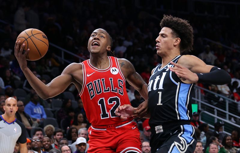 ATLANTA, GEORGIA - FEBRUARY 12:  Ayo Dosunmu #12 of the Chicago Bulls drives against Jalen Johnson #1 of the Atlanta Hawks during the third quarter at State Farm Arena on February 12, 2024 in Atlanta, Georgia.  NOTE TO USER: User expressly acknowledges and agrees that, by downloading and/or using this photograph, user is consenting to the terms and conditions of the Getty Images License Agreement.  (Photo by Kevin C. Cox/Getty Images)