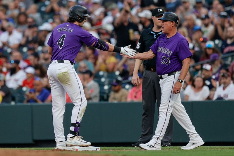 Jul 22, 2024; Denver, Colorado, USA; Colorado Rockies first baseman Michael Toglia (4) reacts with first base coach Ronnie Gideon (53) after hitting an RBI single in the third inning against the Boston Red Sox at Coors Field. Mandatory Credit: Isaiah J. Downing-USA TODAY Sports