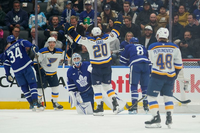 Oct 24, 2024; Toronto, Ontario, CAN; St. Louis Blues forward Brandon Saad (20) celebrates a goal by forward Dylan Holloway (81) against Toronto Maple Leafs goaltender Joseph Woll (60) during the first period at Scotiabank Arena. Mandatory Credit: John E. Sokolowski-Imagn Images