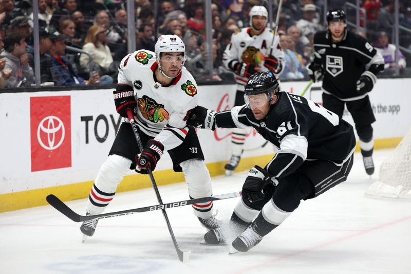 Mar 19, 2024; Los Angeles, California, USA;  Chicago Blackhawks center Andreas Athanasiou (89) passes the puck against Los Angeles Kings center Trevor Lewis (61) during the third period at Crypto.com Arena. Mandatory Credit: Kiyoshi Mio-USA TODAY Sports