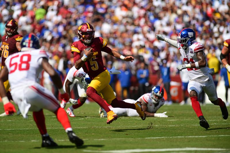 Washington Commanders quarterback Jayden Daniels (5) runs as New York Giants safety Tyler Nubin and Bobby Okereke (58) pursue during the first half of an NFL football game in Landover, Md., Sunday, Sept. 15, 2024. (AP Photo/Steve Ruark)