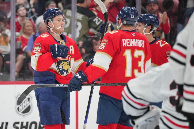 Feb 1, 2025; Sunrise, Florida, USA;  Florida Panthers left wing Matthew Tkachuk (19) celebrates a goal with center Sam Reinhart (13) and center Carter Verhaeghe (23) against the Chicago Blackhawks in the second period at Amerant Bank Arena. Mandatory Credit: Jim Rassol-Imagn Images