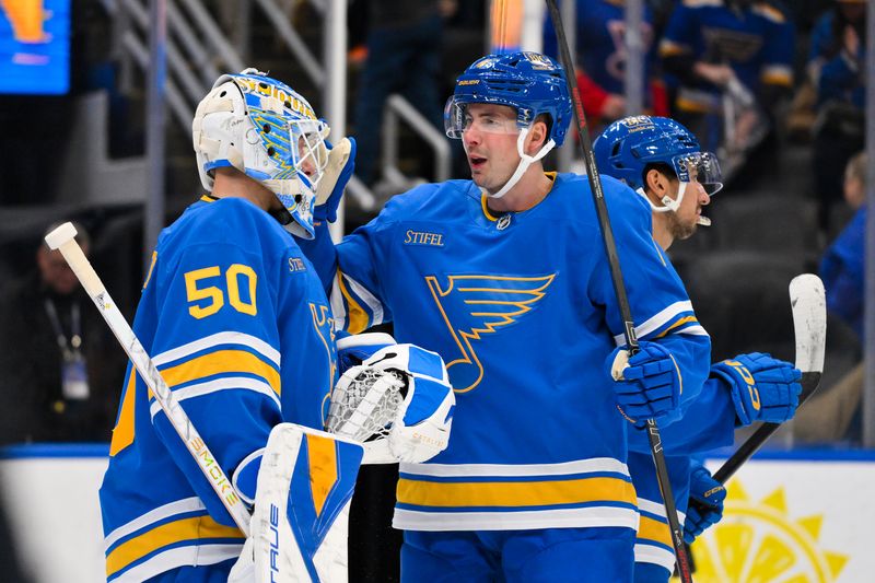 Mar 28, 2026; St. Louis, Missouri, USA; St. Louis Blues defenseman Justin Holl (4) celebrates with goaltender Jordan Binnington (50) after the Blues defeated the Toronto Maple Leafs at Enterprise Center. Mandatory Credit: Jeff Curry-Imagn Images