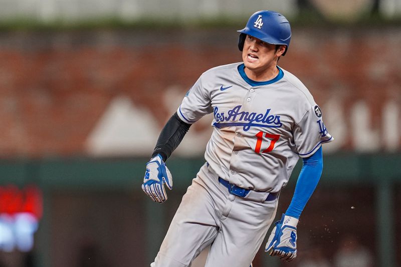 May 3, 2025; Cumberland, Georgia, USA; Los Angeles Dodgers designated hitter Shohei Ohtani (17) runs between second and third base on his way to score a run against the Atlanta Braves during the fourth inning at Truist Park. Mandatory Credit: Dale Zanine-Imagn Images