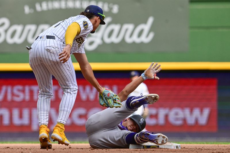 Sep 8, 2024; Milwaukee, Wisconsin, USA; Colorado Rockies shortstop Ezequiel Tovar (14) slides into second base before tag by Milwaukee Brewers shortstop Willy Adames (27) for a double in the fifth inning at American Family Field. Mandatory Credit: Benny Sieu-Imagn Images