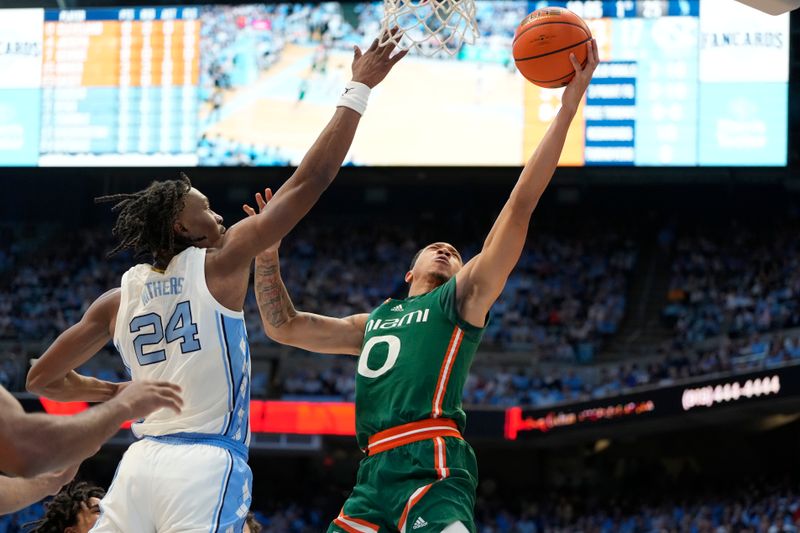 Feb 26, 2024; Chapel Hill, North Carolina, USA; Miami (Fl) Hurricanes guard Matthew Cleveland (0) shoots as North Carolina Tar Heels forward Jae'Lyn Withers (24) defends in the first half at Dean E. Smith Center. Mandatory Credit: Bob Donnan-USA TODAY Sports