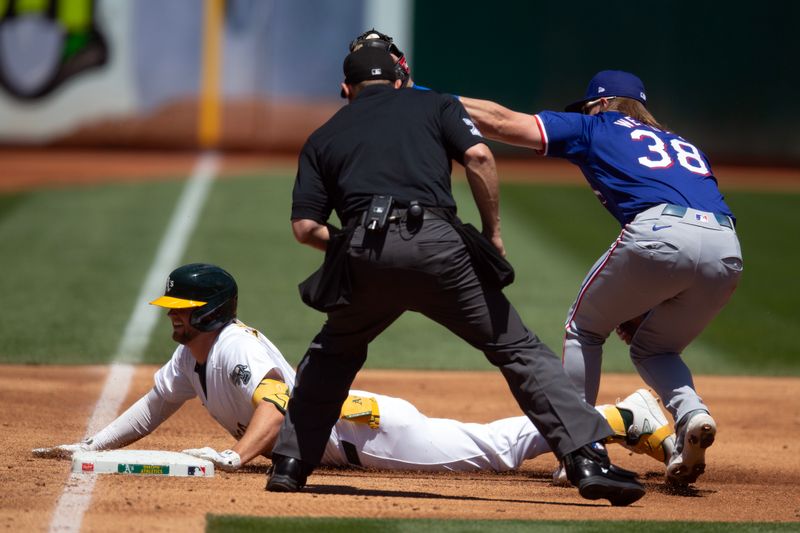 May 8, 2024; Oakland, California, USA; Texas Rangers third baseman Davis Wendzel (38) tags out Oakland Athletics shortstop Max Schuemann (12) at third base as he tries to stretch a double into a triple during the second inning at Oakland-Alameda County Coliseum. Umpire is Tripp Gibson. Mandatory Credit: D. Ross Cameron-USA TODAY Sports