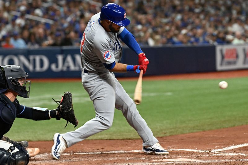 Jun 11, 2024; St. Petersburg, Florida, USA; Chicago Cubs pinch hitter David Bote (13) hits an RBI single in the sixth inning against the Tampa Bay Rays at Tropicana Field. Mandatory Credit: Jonathan Dyer-USA TODAY Sports