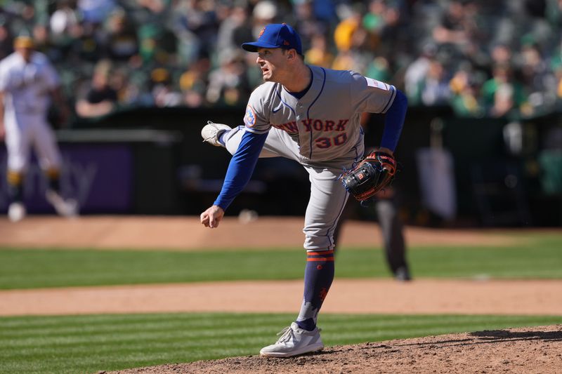 Apr 16, 2023; Oakland, California, USA; New York Mets relief pitcher David Robertson (30) throws a pitch against the Oakland Athletics during the tenth inning at RingCentral Coliseum. Mandatory Credit: Darren Yamashita-USA TODAY Sports