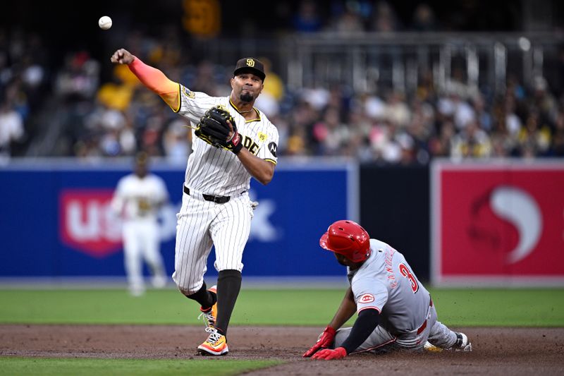 Apr 30, 2024; San Diego, California, USA; San Diego Padres second baseman Xander Bogaerts (2) throws to first base late after forcing out Cincinnati Reds first baseman Jeimer Candelario (3) at second base during the third inning at Petco Park. Mandatory Credit: Orlando Ramirez-USA TODAY Sports