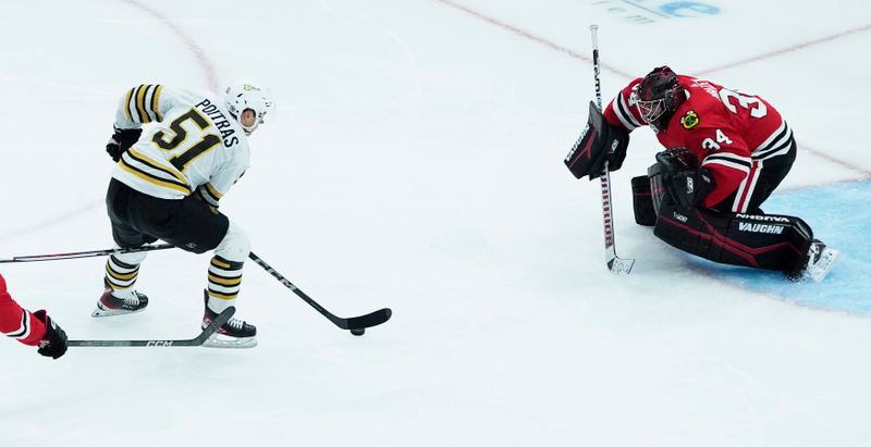 Oct 24, 2023; Chicago, Illinois, USA; Boston Bruins center Matthew Poitras (51) skates in on Chicago Blackhawks goaltender Petr Mrazek (34) during the third period at United Center. Mandatory Credit: David Banks-USA TODAY Sports