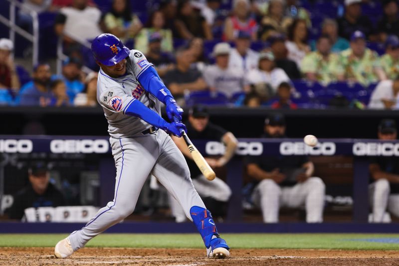 Jul 21, 2024; Miami, Florida, USA; New York Mets second baseman Jose Iglesias (11) hits a single against the Miami Marlins during the fourth inning at loanDepot Park. Mandatory Credit: Sam Navarro-USA TODAY Sports