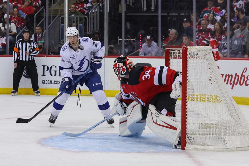 Oct 22, 2024; Newark, New Jersey, USA; Tampa Bay Lightning center Brayden Point (21) looks for the puck after a save by New Jersey Devils goaltender Jake Allen (34) during the first period at Prudential Center. Mandatory Credit: Ed Mulholland-Imagn Images