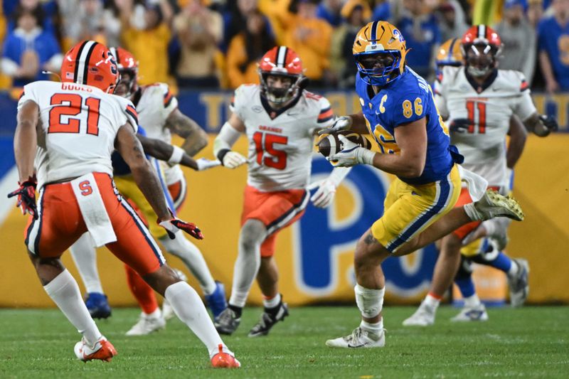 Oct 24, 2024; Pittsburgh, Pennsylvania, USA; Pittsburgh Panthers tight end Gavin Bartholomew (86) makes a catch in front of Syracuse Orange defensive back Jaeden Gould (21) during the third quarter at Acrisure Stadium. Mandatory Credit: Barry Reeger-Imagn Images