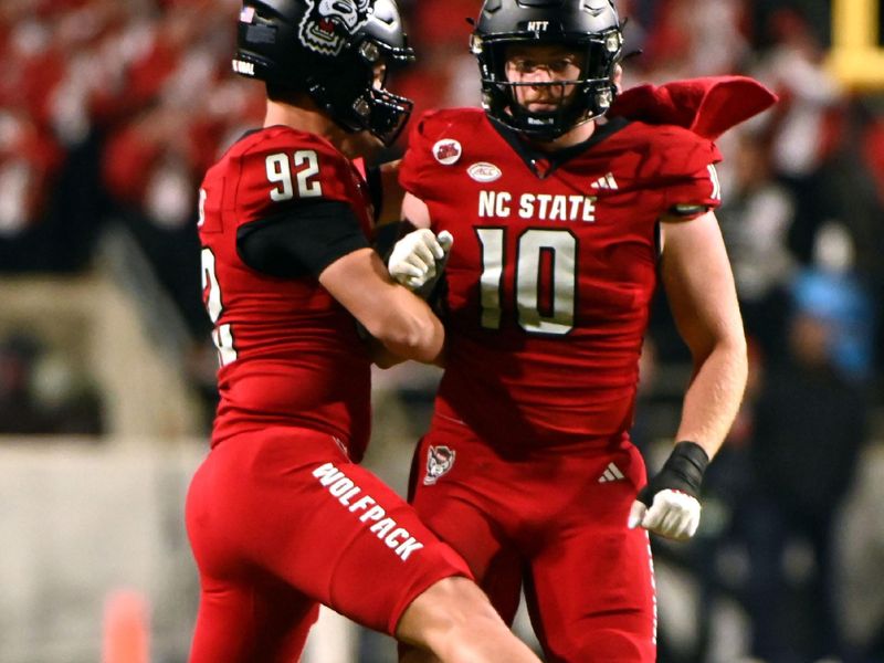 Nov 4, 2023; Raleigh, North Carolina, USA; North Carolina State Wolfpack linebacker Caden Fordham (10) and teammate Aiden Arias (92) react to a fourth down stop during the second half against the Miami Hurricanes at Carter-Finley Stadium.  Mandatory Credit: Rob Kinnan-USA TODAY Sports