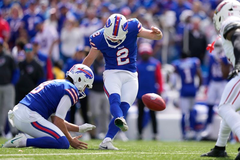 Buffalo Bills place kicker Tyler Bass (2) kicks a field goal against the Arizona Cardinals with the help of Bills holder Sam Martin, left, during the first half of an NFL football game Sunday, Sept. 8, 2024, in Orchard Park, N.Y. (AP Photo/Matt Slocum)